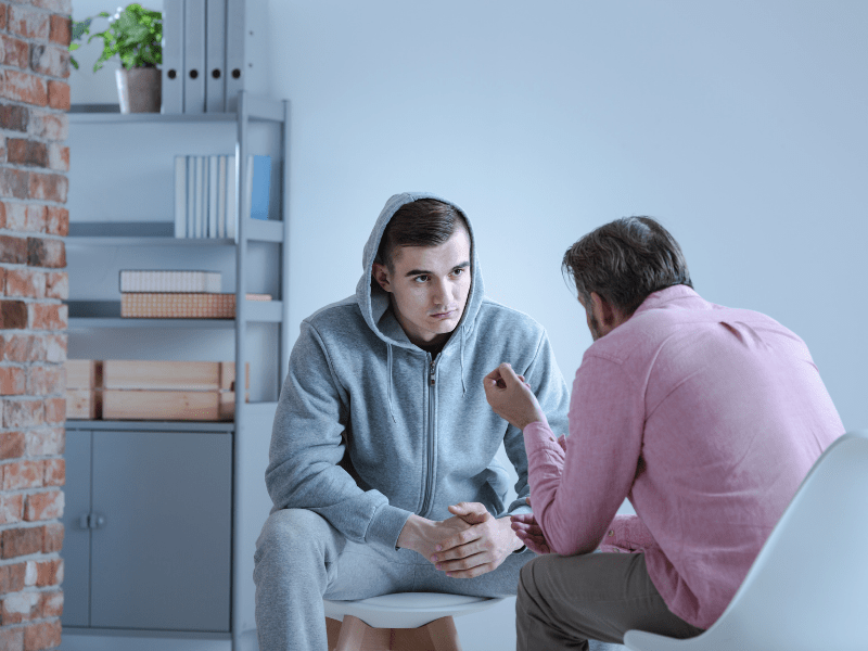 A counsellor sits with a client in an addiction rehab treatment centre
