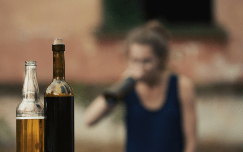 Woman drinking alcohol out of a bottle