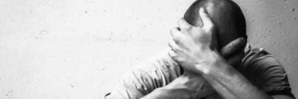 man with head in hands - suffering from drug and alcohol addiction