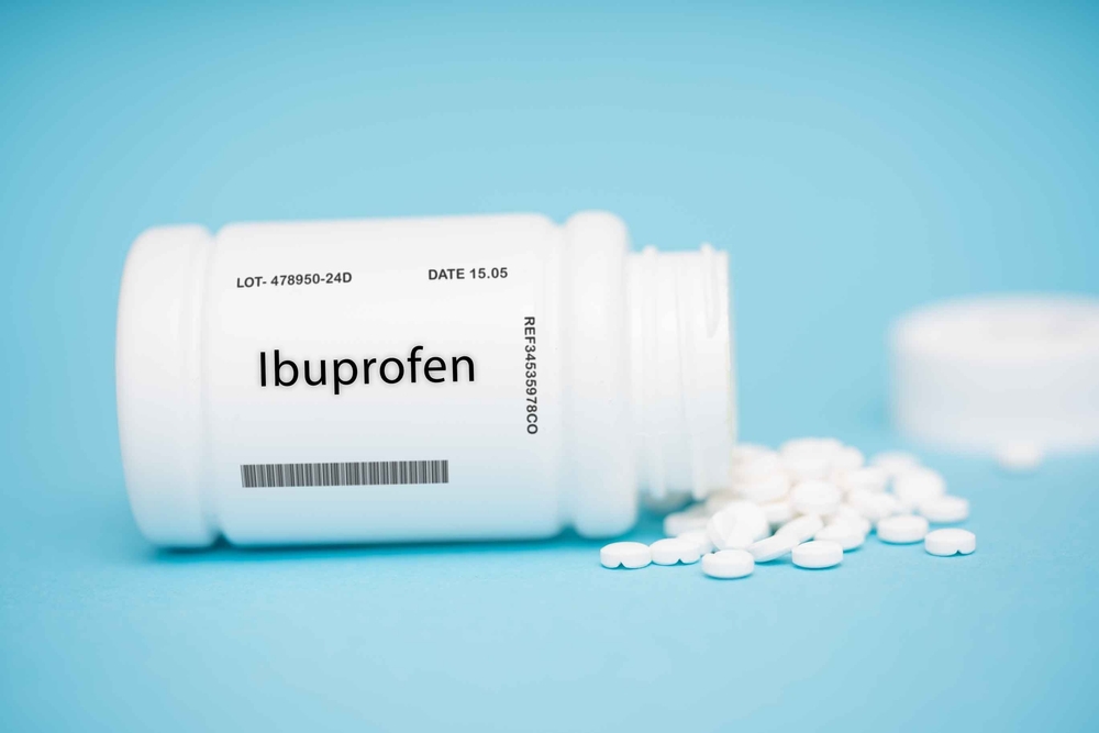 Ibuprofen bottle with tablets on the ground