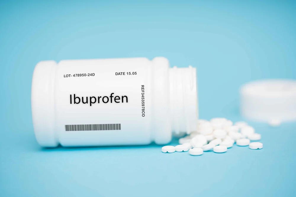 Ibuprofen bottle with tablets on the ground