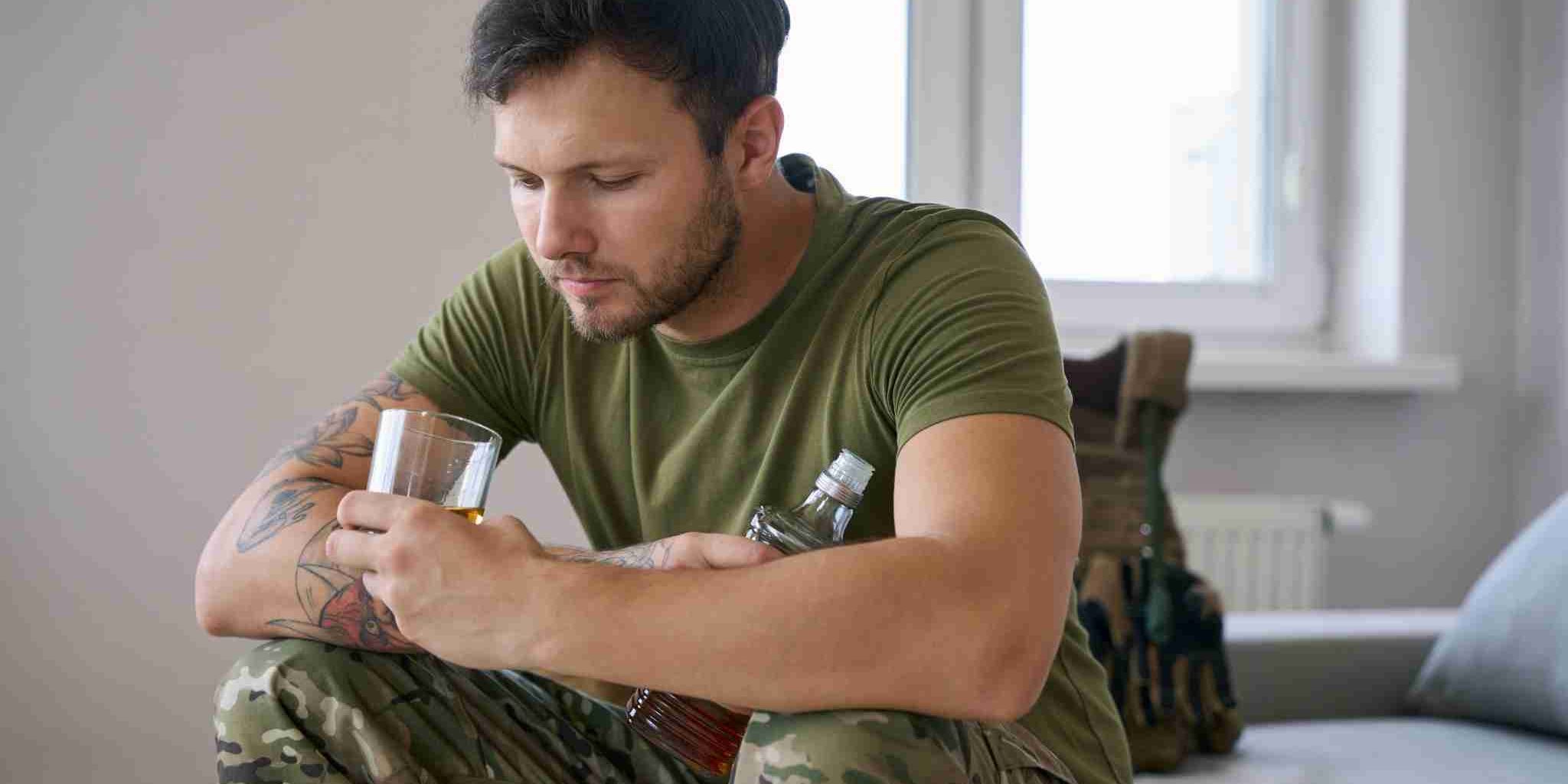 Person_looking_into_a_bottle A soldier looking into a bottle as they duffer with PTSD and alcohol addiction