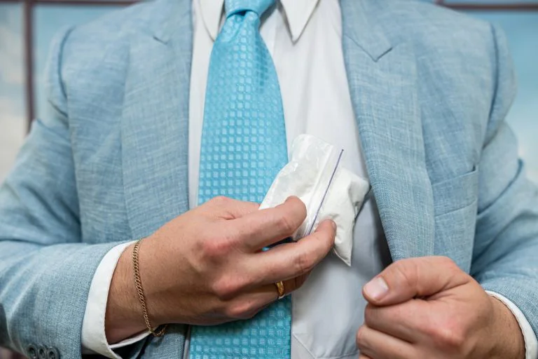 Man in a suit with a bag of cocaine