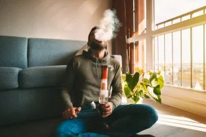 Man using a bong for Weed