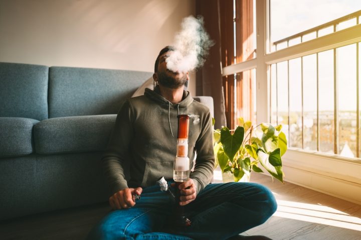 Man,Smoking,Bong,And,Exhaling,The,Smoke,At,Home.,Man Man using a bong for Weed