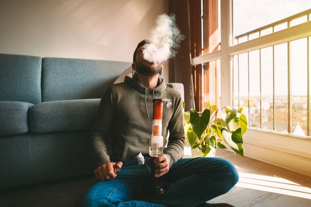 Man using a bong for Weed