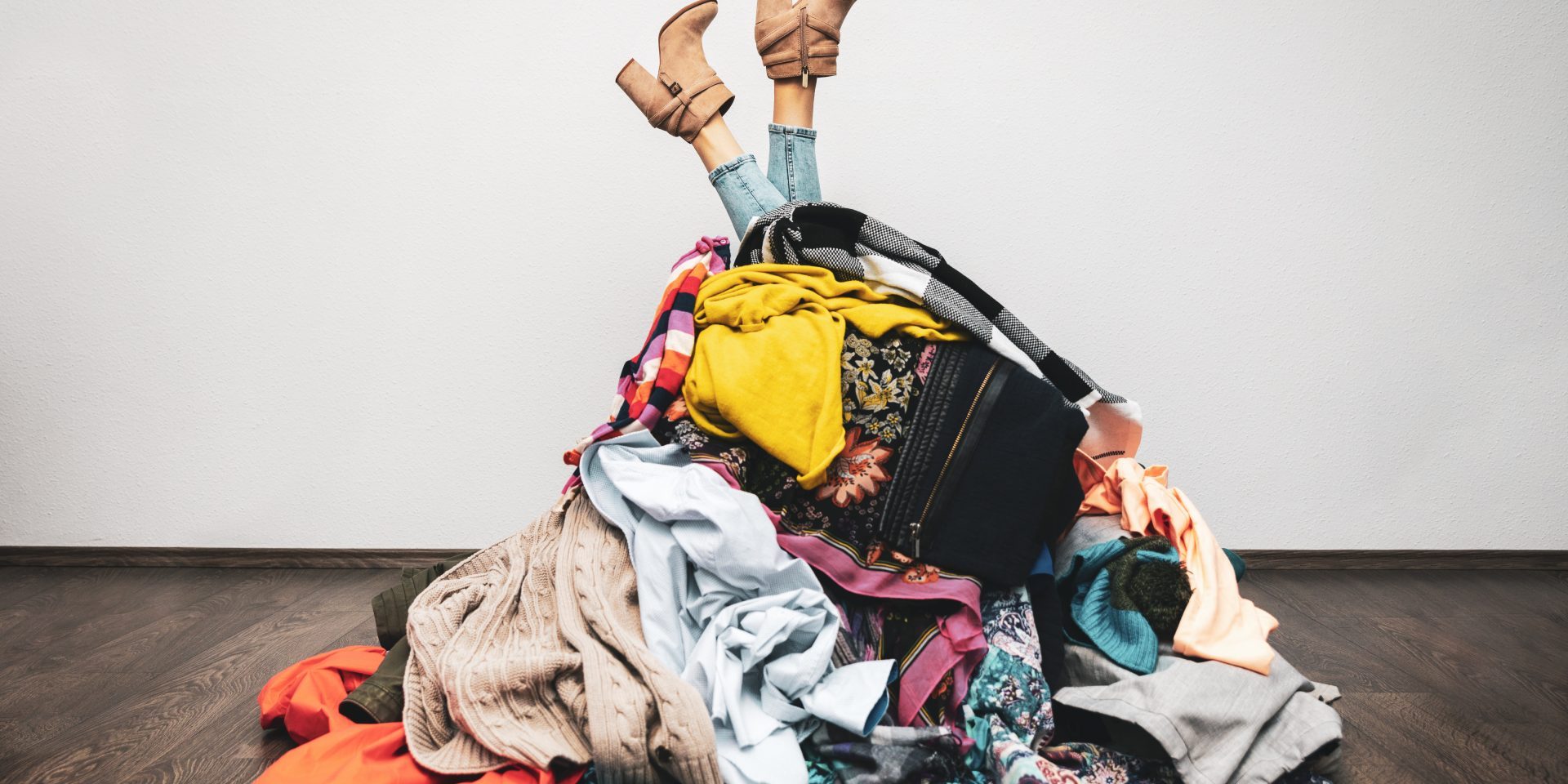 Woman,Legs,Out,Of,A,Pile,Of,Clothes,On,The Shopping addiction