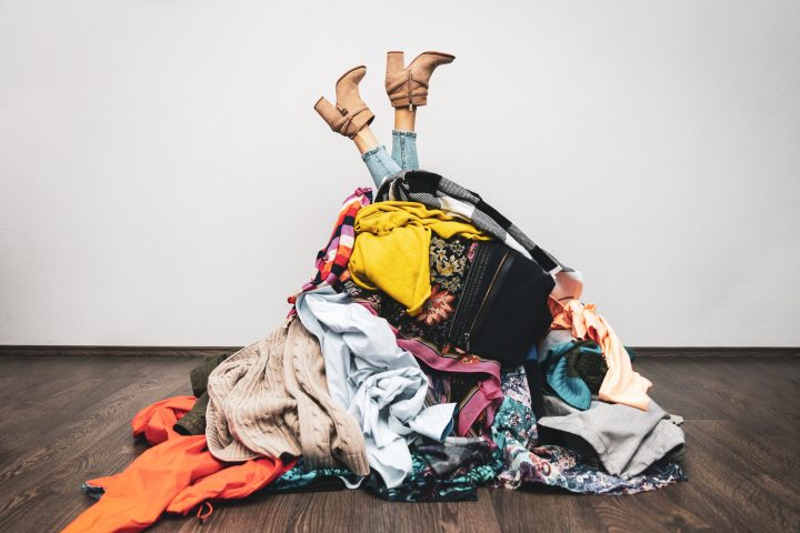 Woman,Legs,Out,Of,A,Pile,Of,Clothes,On,The Shopping addiction