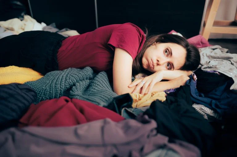 Woman lying on clothes she has bought