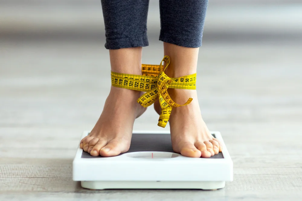 Unrecognizable,Indian,Woman,Standing,On,Scales,With,Tied,Feet,,Checking Addicted to lossing weight