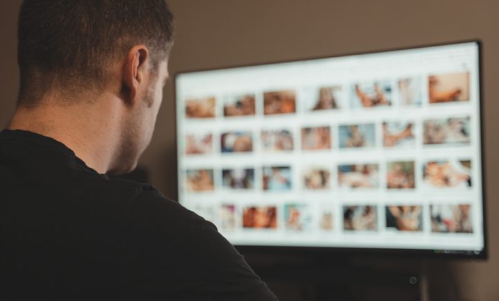 Man,Browsing,Porn,Site,Late,At,Night. Man views porn late at night porn is blurred