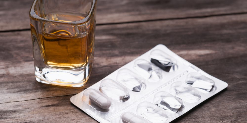 Whiskey,Or,Bourbon,In,A,Shot,Glass,And,Pack,Of Antibiotics with alcohol