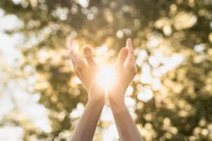 Hand Holding the sun to show nature
