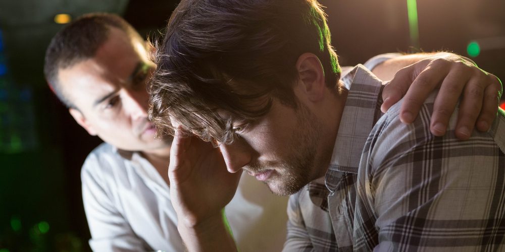 Man,Comforting,His,Depressed,Friend,In,Bar Supporting a friend through relapse