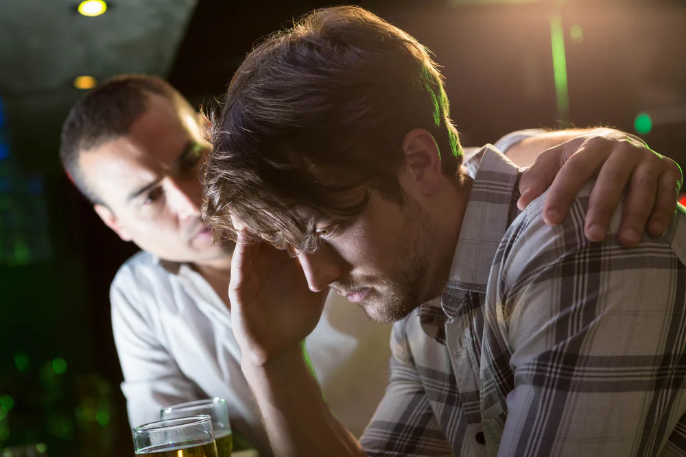 Man,Comforting,His,Depressed,Friend,In,Bar Supporting a friend through relapse