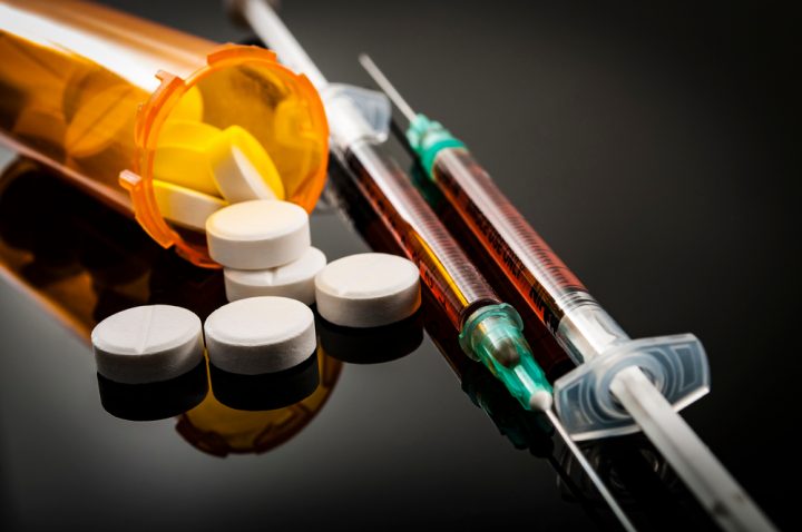 Opioid,Epidemic,,Drug,Abuse,Concept,With,Closeup,On,Two,Heroin Methadone in a bottle and needle