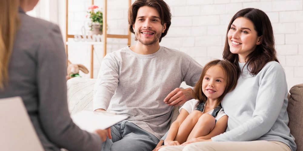 Happy,Parents,With,Little,Daughter,Sitting,Together,At,Psycholigist’s,Office Family Therapy