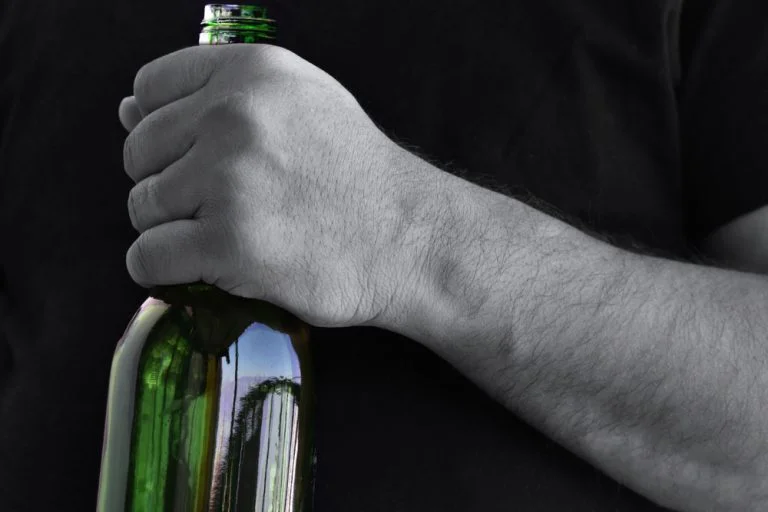 Hand holding a bottle of alcohol