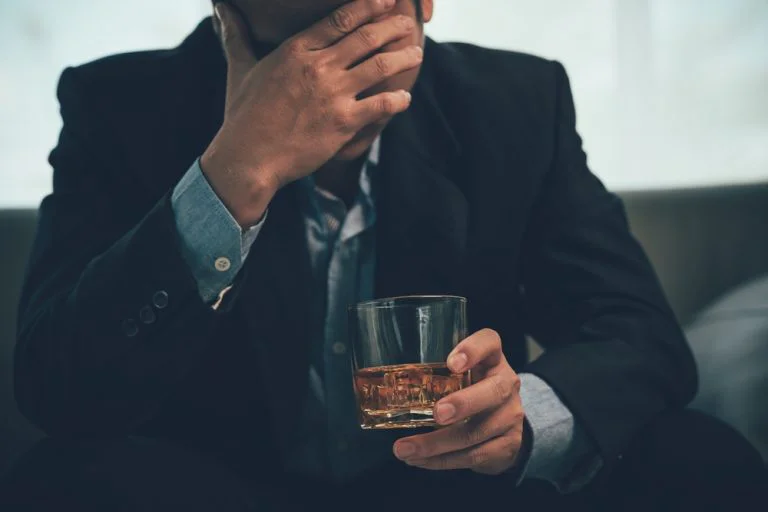 Businessman drinking alone as he is stressed