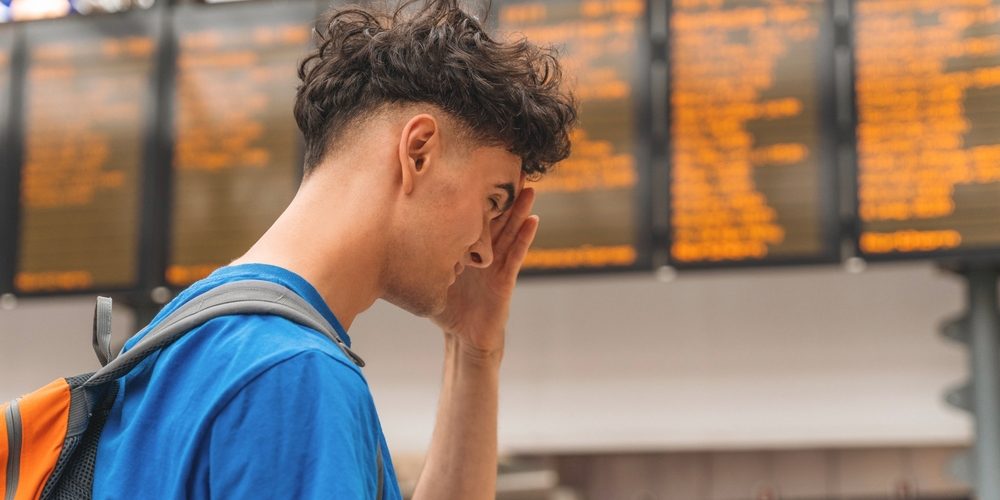 Young,Traveler,Checking,Train,Schedules,At,Busy,Transit,Station,During Train Travel to rehab