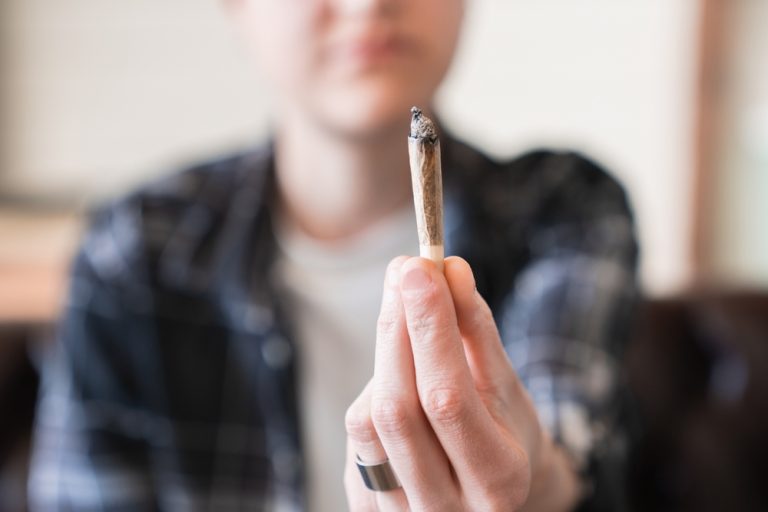 Individual holding a cannabis joint