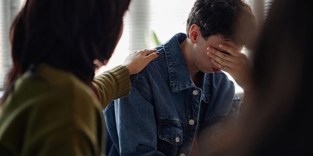 Teenage,Caucasian,Boy,Sitting,With,Hand,Covering,Face,,Showing,Distress Young man in an alcohol intervention