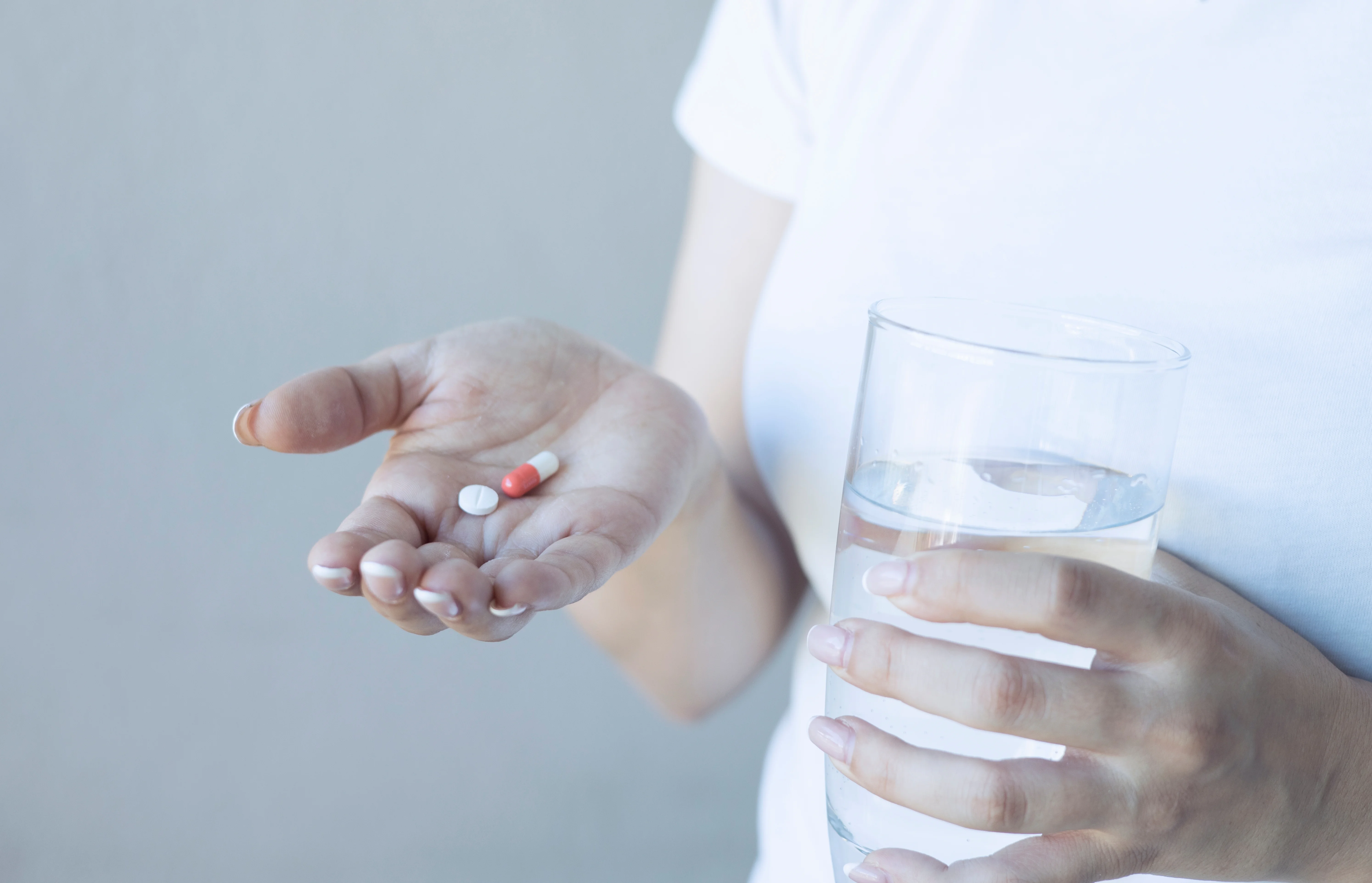 Woman,Holding,Colorful,Pills,And,Glass,Of,Drinking,Water Etizolam Addiction