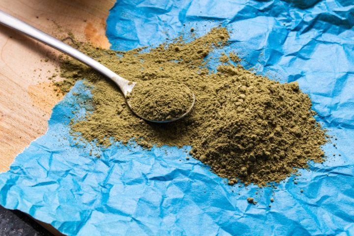 Big,Pile,Of,Green,Powdered,Kratom,On,Blue,Crampled,Paper Kratom Powder