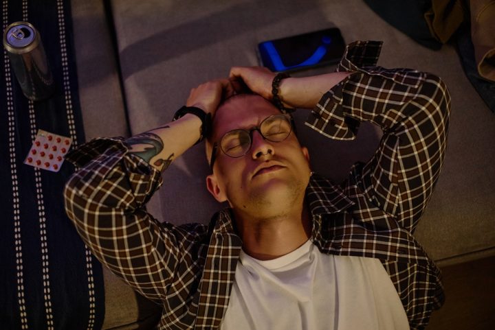High,Angle,Shot,Of,Exhausted,Caucasian,Young,Adult,Man,Holding Burnout and addiction
